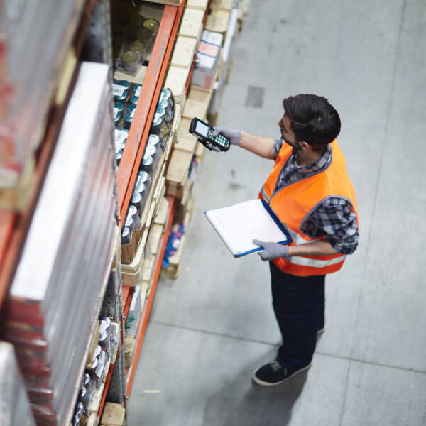 Warehouse employee working in warehouse while wearing a high-vis vest