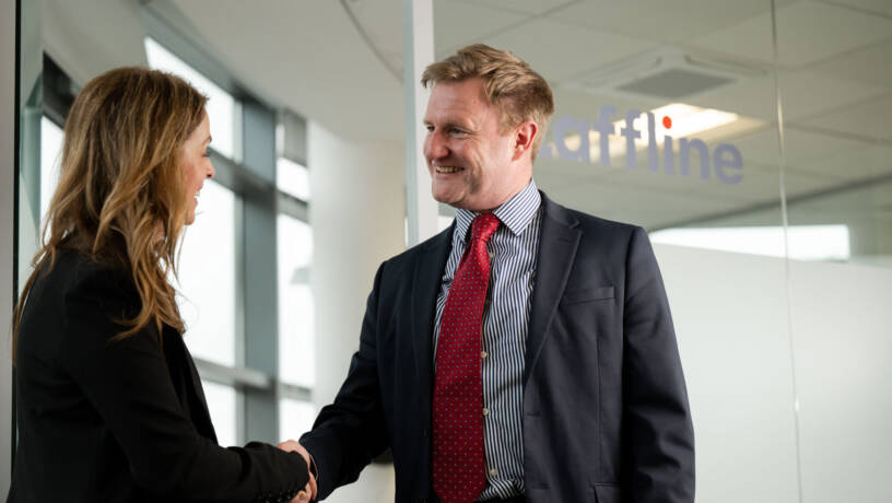 Two people shaking hands and smiling